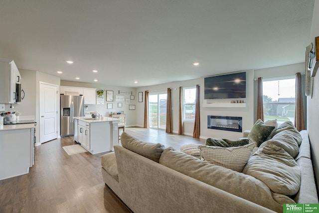 4411 Schilling Dr, Bellevue, NE 68123 - living room with dark wood-style floors, a glass covered fireplace, and recessed lighting
