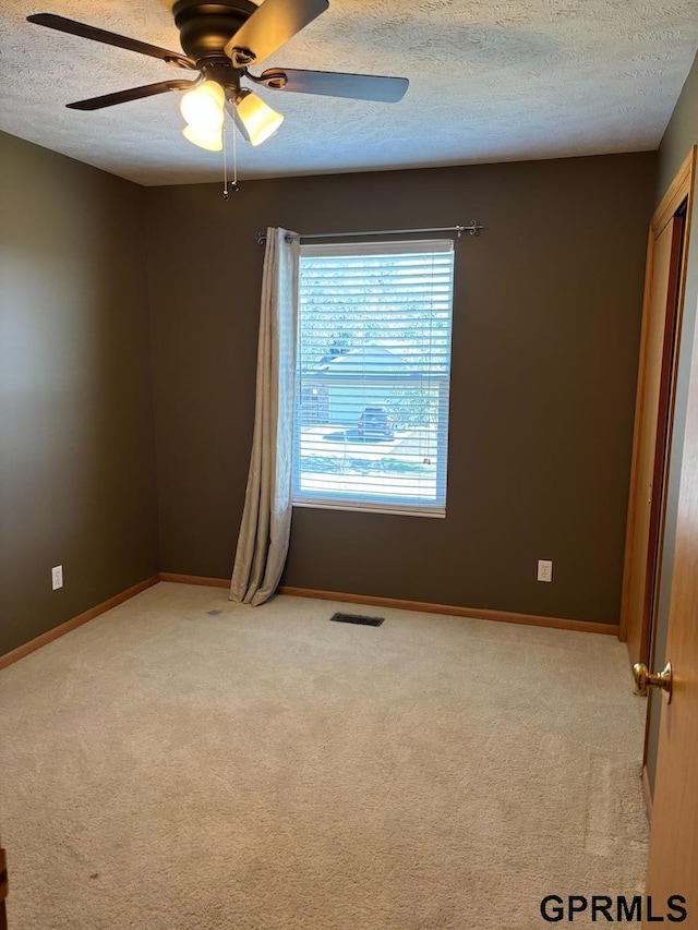 2110 Herel St, Lincoln, NE 68512 - empty room featuring a textured ceiling, a ceiling fan, light colored carpet, and baseboards