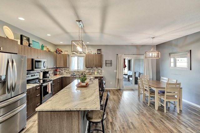 1946 Eastgate Dr, Crete, NE 68333 - kitchen featuring stainless steel appliances, a breakfast bar area, healthy amount of natural light, backsplash, and recessed lighting