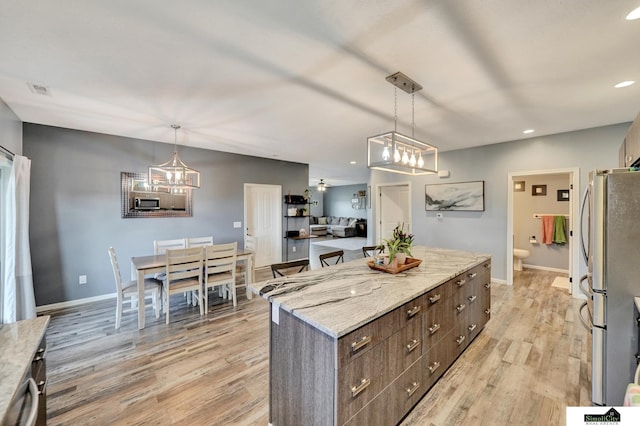 1946 Eastgate Dr, Crete, NE 68333 - kitchen with a center island, appliances with stainless steel finishes, light wood-style floors, dark brown cabinetry, and recessed lighting