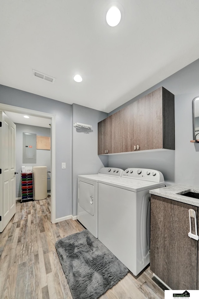 1946 Eastgate Dr, Crete, NE 68333 - laundry room with cabinet space, washing machine and clothes dryer, electric panel, light wood-type flooring, and recessed lighting