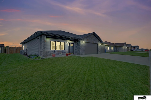 1946 Eastgate Dr, Crete, NE 68333 - view of front of property with stone siding, driveway, an attached garage, and central AC