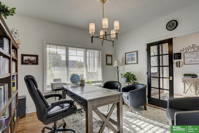 office area featuring light wood-type flooring, a chandelier, and baseboards