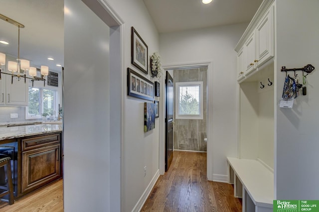 mudroom featuring plenty of natural light, light wood-style flooring, recessed lighting, a chandelier, and baseboards