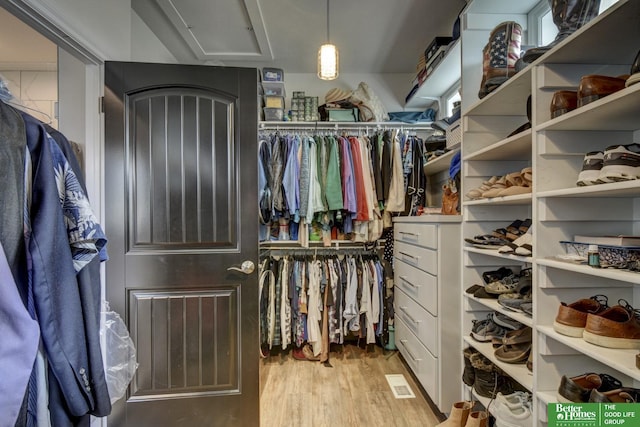 spacious closet with wood finished floors and attic access