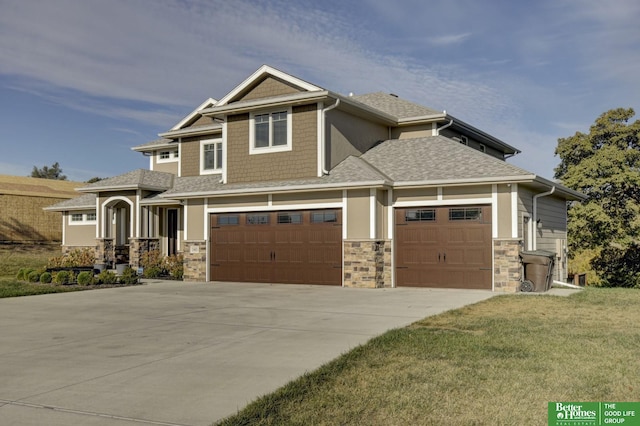 view of front of house featuring concrete driveway, stone siding, a front lawn, a shingled roof, and a garage