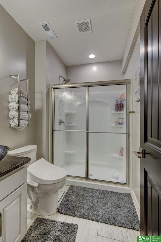 full bathroom with a stall shower, toilet, and vanity