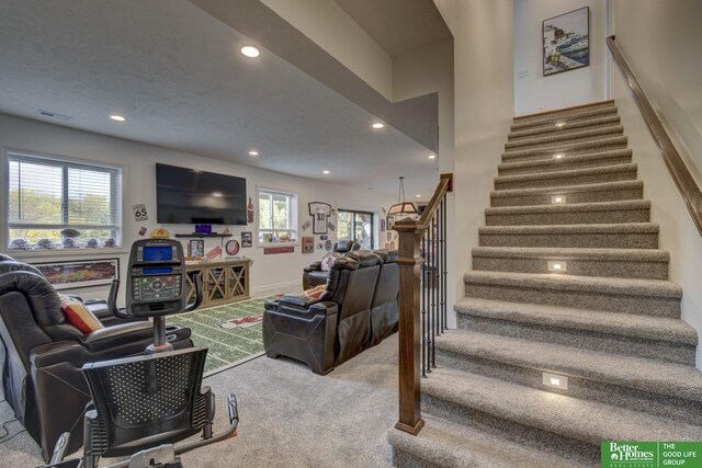 stairway with carpet floors and recessed lighting