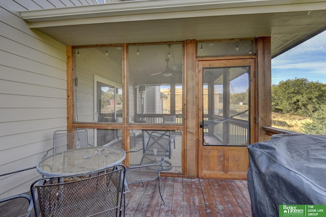 wooden deck with a sunroom and outdoor dining space
