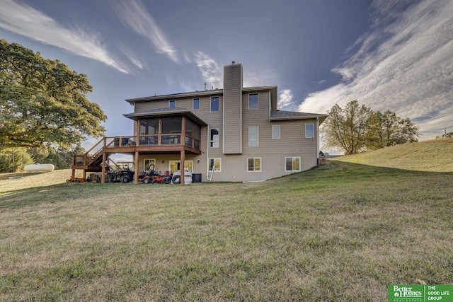 back of property with a sunroom, a chimney, a lawn, a deck, and stairway