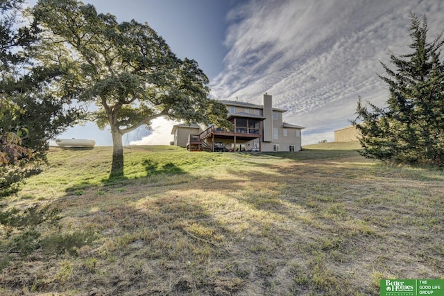 view of green lawn with a wooden deck