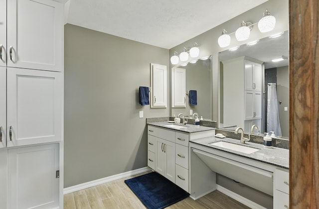 17819 Nicholas Rd, Plattsmouth, NE 68048 - bathroom featuring wood finished floors, double vanity, and baseboards