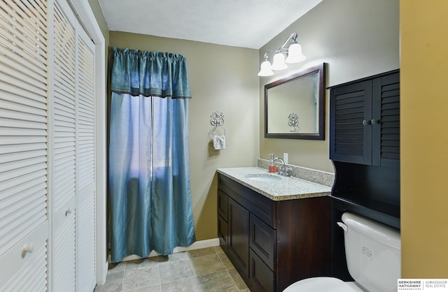 17819 Nicholas Rd, Plattsmouth, NE 68048 - bathroom featuring a closet, toilet, vanity, stone finish floors, and baseboards