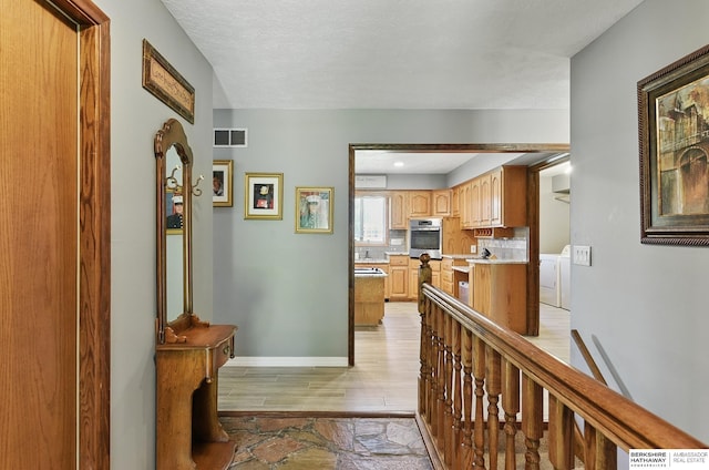17819 Nicholas Rd, Plattsmouth, NE 68048 - corridor with washer and dryer, light wood-style flooring, and baseboards
