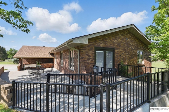 17819 Nicholas Rd, Plattsmouth, NE 68048 - back of property with brick siding, a patio area, and french doors