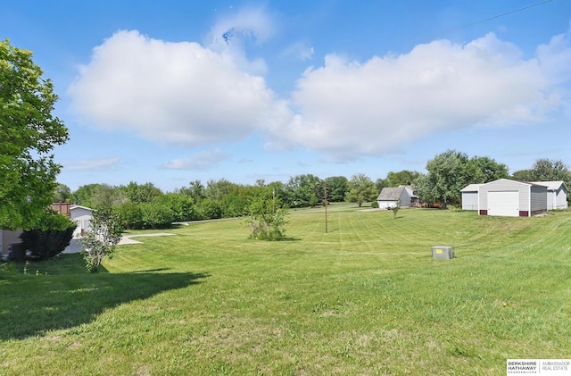 17819 Nicholas Rd, Plattsmouth, NE 68048 - view of green lawn featuring an outbuilding, a garage, and view of wooded area