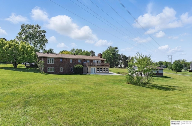 17819 Nicholas Rd, Plattsmouth, NE 68048 - rear view of house with a yard, a chimney, and brick siding