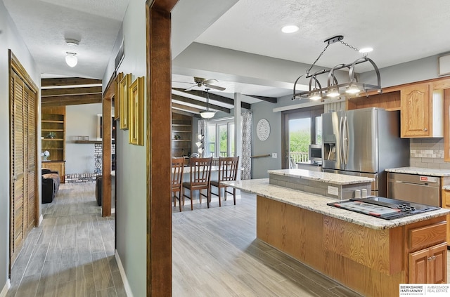 17819 Nicholas Rd, Plattsmouth, NE 68048 - kitchen featuring stainless steel refrigerator with ice dispenser, a kitchen island, a ceiling fan, light wood-style floors, and a textured ceiling