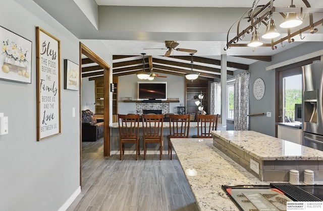 17819 Nicholas Rd, Plattsmouth, NE 68048 - dining area featuring ceiling fan, a brick fireplace, light wood-type flooring, and baseboards