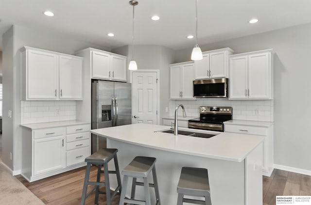 10280 S 209th St, Gretna, NE 68028 - kitchen with stainless steel appliances, a sink, wood finished floors, backsplash, and white cabinetry
