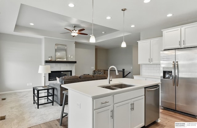 10280 S 209th St, Gretna, NE 68028 - kitchen with stainless steel appliances, a sink, a kitchen island with sink, a raised ceiling, and recessed lighting