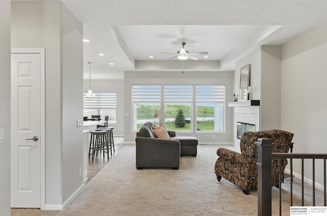 10280 S 209th St, Gretna, NE 68028 - carpeted living room with baseboards, a ceiling fan, a raised ceiling, recessed lighting, and a tiled fireplace