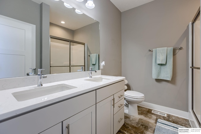 2310 Acorn Dr, Plattsmouth, NE 68048 - bathroom with a shower stall, baseboards, toilet, and double vanity