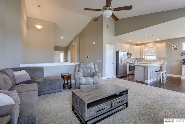 2310 Acorn Dr, Plattsmouth, NE 68048 - living area featuring dark colored carpet, ceiling fan, high vaulted ceiling, and baseboards