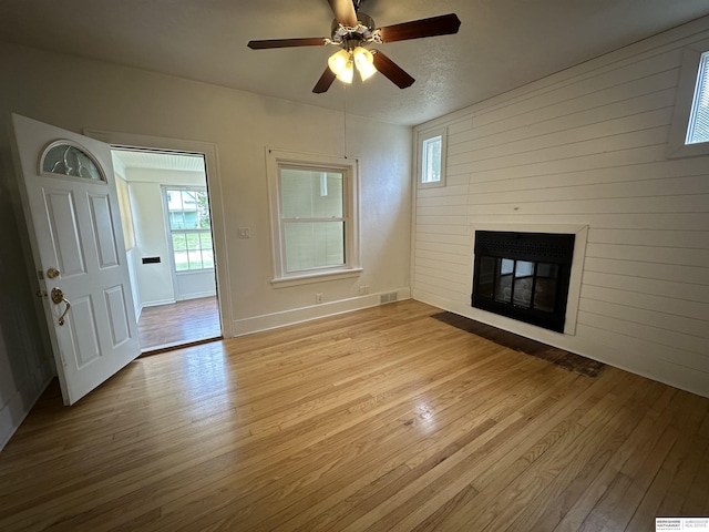 2002 Warren St, Bellevue, NE 68005 - unfurnished living room with wood-type flooring, a fireplace with flush hearth, a ceiling fan, and baseboards