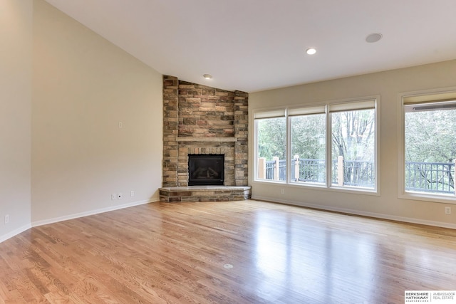 1414 S 189th Ct, Omaha, NE 68130 - unfurnished living room with wood finished floors, vaulted ceiling, a stone fireplace, baseboards, and recessed lighting