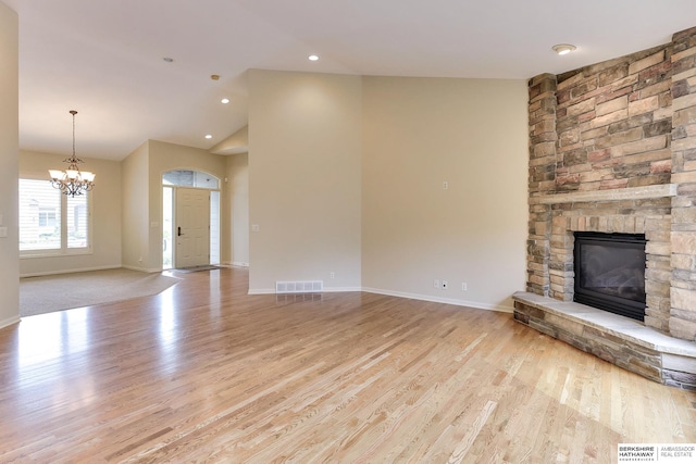 1414 S 189th Ct, Omaha, NE 68130 - unfurnished living room with a stone fireplace, a chandelier, wood finished floors, baseboards, and vaulted ceiling