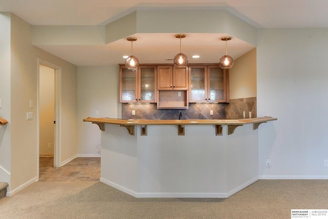 1414 S 189th Ct, Omaha, NE 68130 - kitchen featuring a breakfast bar, light carpet, glass insert cabinets, and brown cabinets