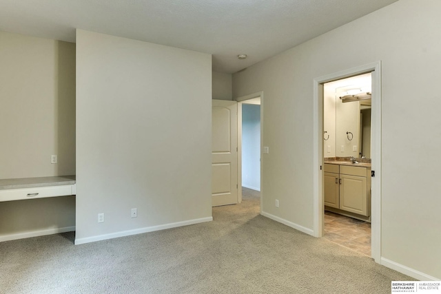 1414 S 189th Ct, Omaha, NE 68130 - unfurnished bedroom with light carpet, baseboards, ensuite bathroom, and a sink