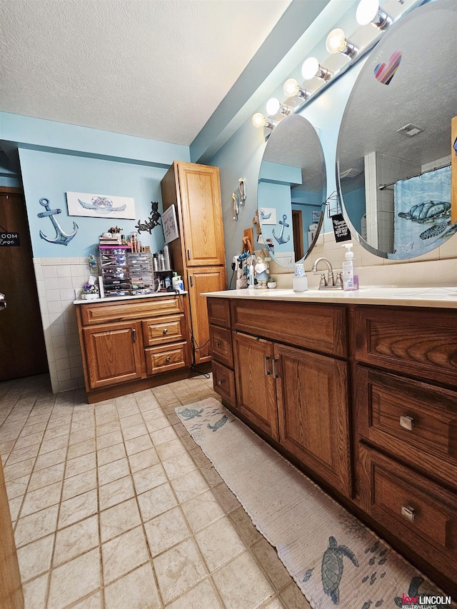 10531 N 137th St, Waverly, NE 68462 - full bathroom with a textured ceiling, vanity, tile patterned flooring, tile walls, and a shower with curtain