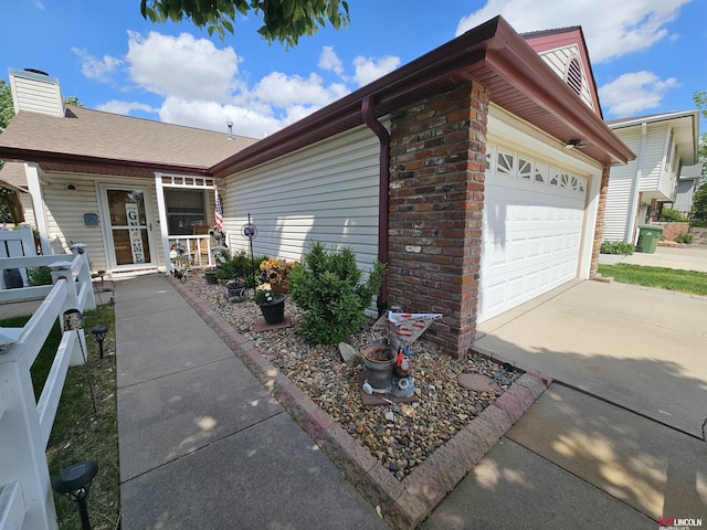 10531 N 137th St, Waverly, NE 68462 - view of home's exterior with a chimney, concrete driveway, an attached garage, and covered porch