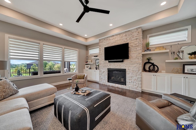 8947 Himark Ln, Lincoln, NE 68526 - living area with dark wood-style floors, a ceiling fan, a fireplace, recessed lighting, and a raised ceiling