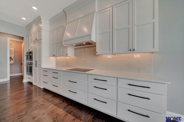 8947 Himark Ln, Lincoln, NE 68526 - kitchen featuring custom range hood, black electric cooktop, baseboards, light countertops, and recessed lighting