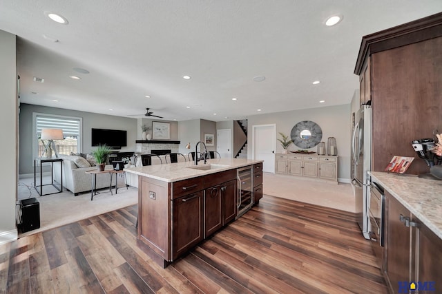 8947 Himark Ln, Lincoln, NE 68526 - kitchen featuring a sink, wine cooler, dark wood-type flooring, a ceiling fan, and a fireplace