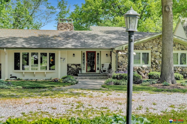 9900 Van Dorn St, Lincoln, NE 68520 - view of front of property featuring stone siding, a chimney, covered porch, and a shingled roof