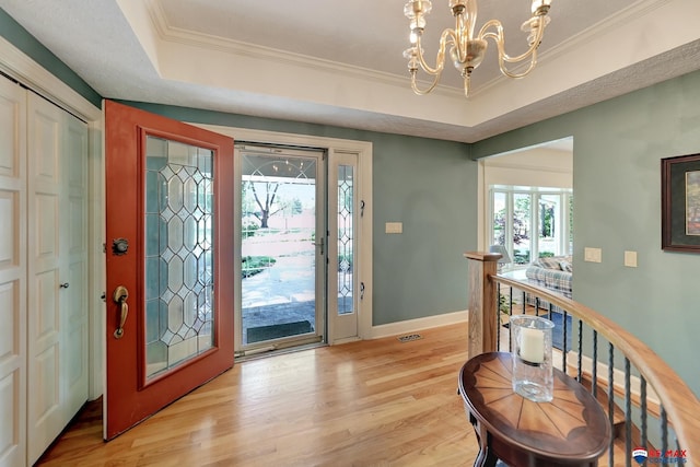 9900 Van Dorn St, Lincoln, NE 68520 - entrance foyer with a tray ceiling, light wood finished floors, a chandelier, baseboards, and crown molding