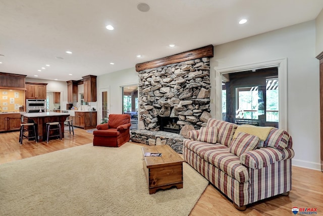 9900 Van Dorn St, Lincoln, NE 68520 - living room featuring a stone fireplace, recessed lighting, light wood finished floors, and baseboards