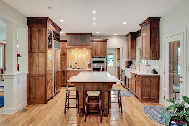 9900 Van Dorn St, Lincoln, NE 68520 - kitchen featuring stainless steel appliances, a sink, light wood-style flooring, a breakfast bar, and recessed lighting