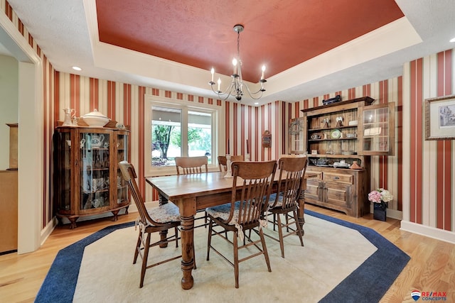 9900 Van Dorn St, Lincoln, NE 68520 - dining space with wallpapered walls, a tray ceiling, light wood-style flooring, a chandelier, and baseboards