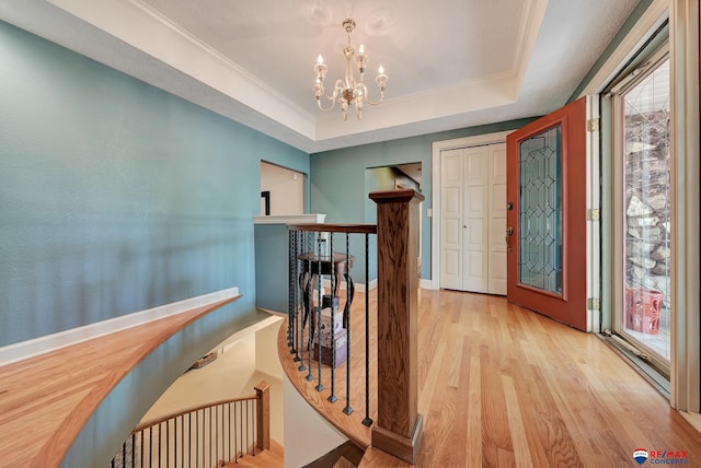 9900 Van Dorn St, Lincoln, NE 68520 - hall featuring an upstairs landing, healthy amount of natural light, a tray ceiling, a chandelier, and crown molding
