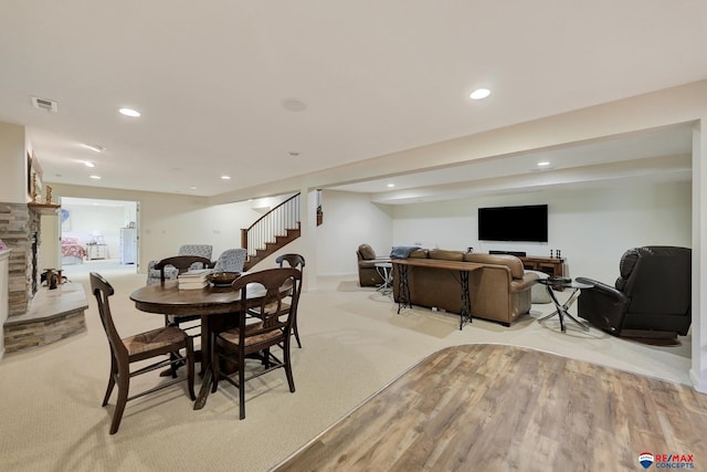 9900 Van Dorn St, Lincoln, NE 68520 - dining space with stairway, recessed lighting, a stone fireplace, light carpet, and light wood finished floors