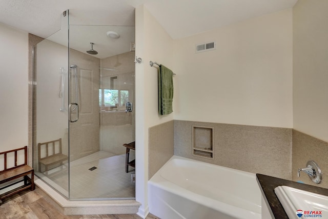 9900 Van Dorn St, Lincoln, NE 68520 - full bathroom with a sink, a garden tub, a stall shower, and wood finished floors