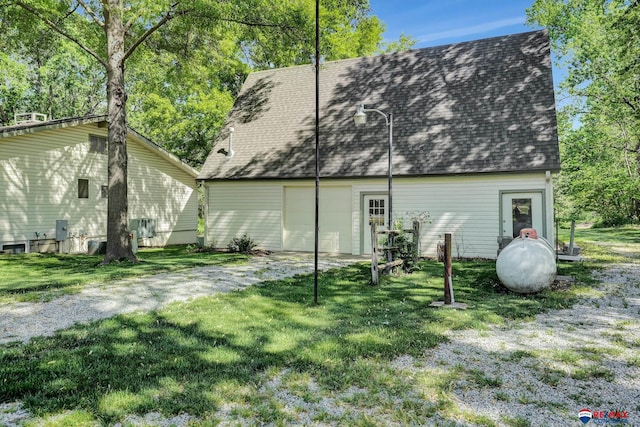9900 Van Dorn St, Lincoln, NE 68520 - rear view of property featuring a garage, a yard, a shingled roof, and driveway