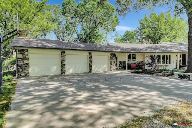 9900 Van Dorn St, Lincoln, NE 68520 - view of front of property with an attached garage, concrete driveway, a chimney, and stone siding