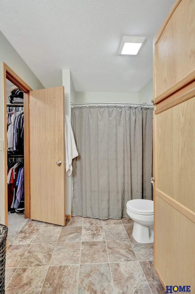 2222 SW Soukup Dr, Lincoln, NE 68522 - full bath with stone finish floors, toilet, a shower with curtain, and a walk in closet