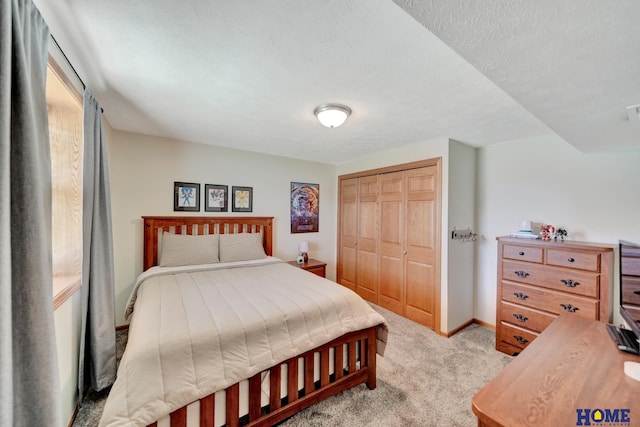 2222 SW Soukup Dr, Lincoln, NE 68522 - bedroom with light carpet, a closet, baseboards, and a textured ceiling